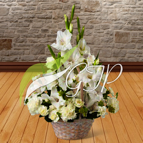 A wicker basket with 5 glads and 4 chrysanthemums in white and yellow colors, surrounded by green leaves and tied with a ribbon.