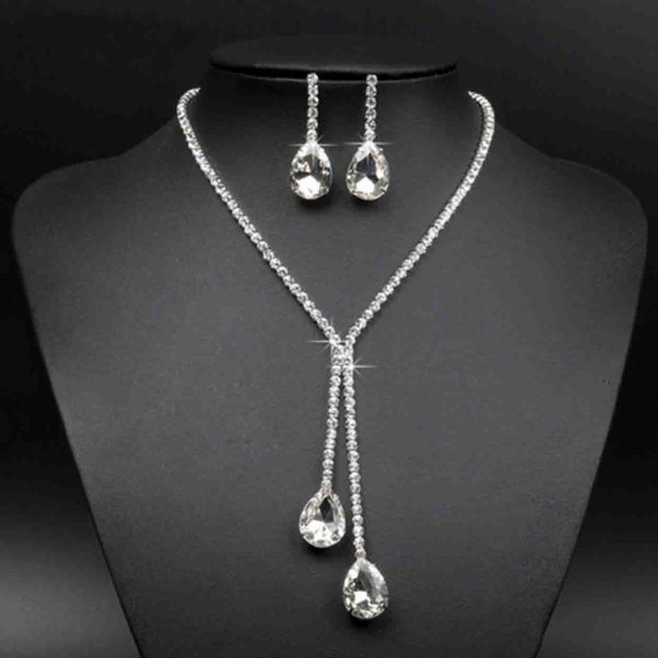 A set of silver necklace and earrings with moon-shaped pendants and cubic zirconia stones.