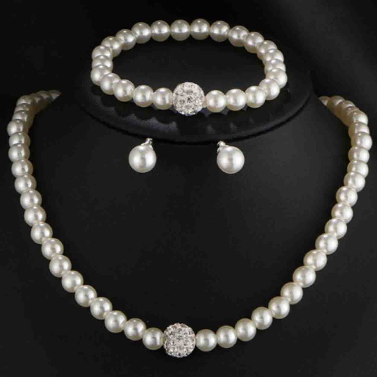 A necklace, earrings, and a bracelet made of faux pearls in clusters and strands with silver-tone metal accents. The jewelry set is called Pearl Essence.
