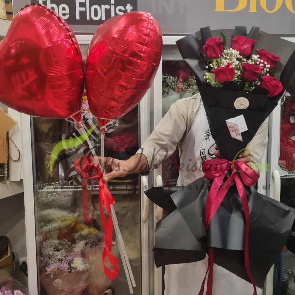 Passionate Embrace: “An elegant bouquet of imported red roses paired with two heart-shaped foil balloons, symbolizing a heartfelt romantic gesture.”